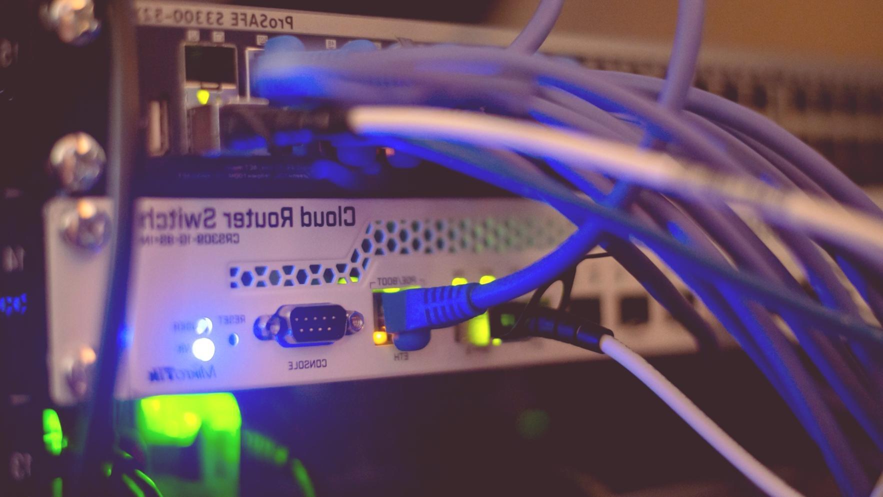 Specialista IT che analizza metriche di performance su monitor multipli